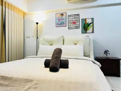 a bedroom with a bed with a stuffed animal on it at Kuala Lumpur City Center By Summer Suites in Kuala Lumpur