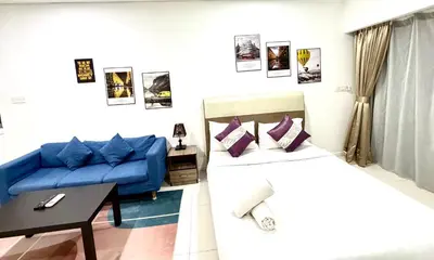 a living room with two beds and a blue couch at Kuala Lumpur City Center By Summer Suites in Kuala Lumpur