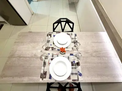 a table with two white plates on top of it at Kuala Lumpur City Center By Summer Suites in Kuala Lumpur