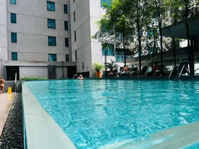 a large swimming pool in front of a building at Kuala Lumpur City Center By Summer Suites in Kuala Lumpur