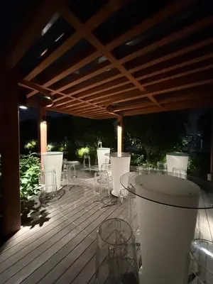 a deck with white chairs and a table on it at Majestic Suites KLCC By Fortune in Kuala Lumpur