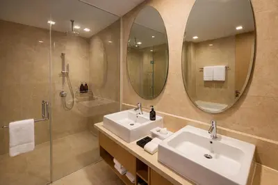 a bathroom with two sinks and a shower and a mirror at Cormar Residences Kuala Lumpur in Kuala Lumpur