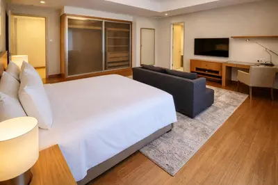 a bedroom with a bed and a couch and a television at Cormar Residences Kuala Lumpur in Kuala Lumpur