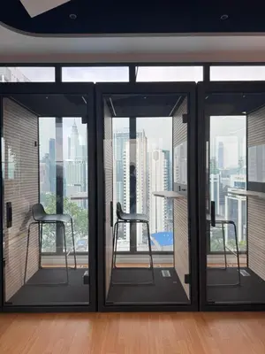 a room with windows with chairs and a view of the city at Majestic Serviced Suites KLCC in Kuala Lumpur
