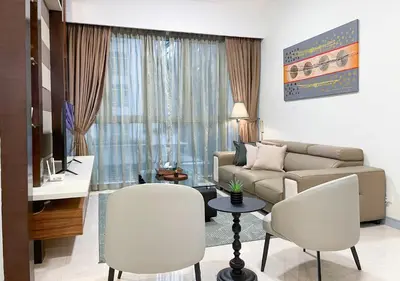 a living room with a couch and a table and chairs at MARC Residence KLCC by VastHaven in Kuala Lumpur