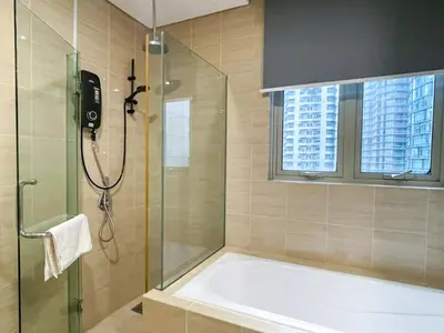 a bathroom with a tub and a shower with a window at MARC Residence KLCC by VastHaven in Kuala Lumpur