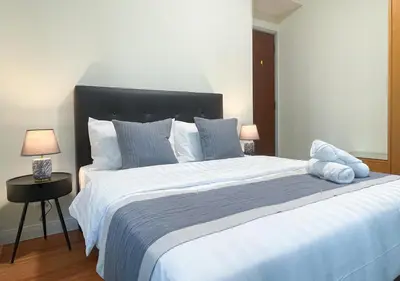 a bedroom with a large white bed with two lamps at MARC Residence KLCC by VastHaven in Kuala Lumpur
