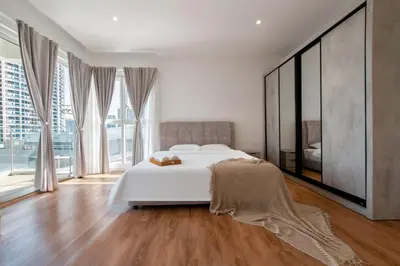 a bedroom with a white bed and large windows at KLCC Quill Residences by Avery #Located in the City Center #10 mins walk to Twin Towers #Infinity pool#\u4e2d\u82f1\u6587\u623f\u4e1c in Kuala Lumpur