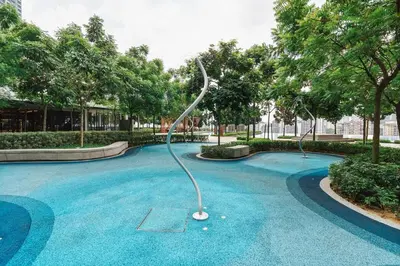 a dolphin statue in a swimming pool with trees at Ancestry 3BR M Vertica MRT Access by RumaBnB in Kuala Lumpur
