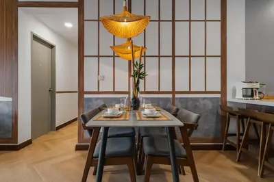 a dining room with a table with chairs and a lamp at Ancestry 3BR M Vertica MRT Access by RumaBnB in Kuala Lumpur