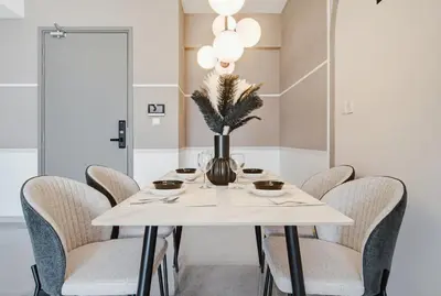 a white dining room table with chairs and a vase with flowers at Prestige 2BR Agile BB WiFi Netflix in Kuala Lumpur