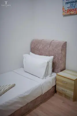 a bed with white pillows and a night stand at Arte Plus Luxury Suites with KLCC View in Kuala Lumpur