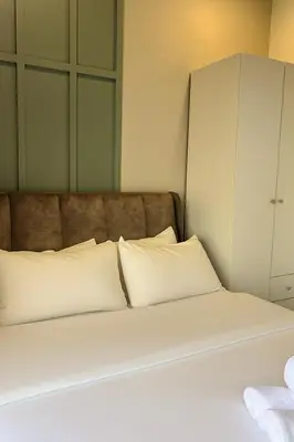 a bed with white pillows in a room at Neu Suites Apartments by LammyNora in Kuala Lumpur