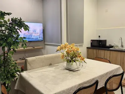 a dining room table with a vase of flowers on it at Neu Suites Apartments by LammyNora in Kuala Lumpur