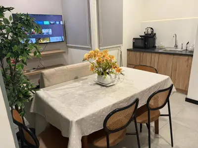 a white table with a vase of flowers on it at Neu Suites Apartments by LammyNora in Kuala Lumpur