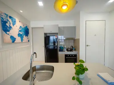 a kitchen with a sink and a refrigerator at TRION The 108 Family Suite Pool & City view in Kuala Lumpur