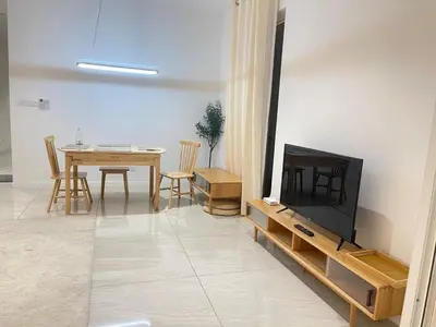 a living room with a television and a table with chairs at Quill Comport Suits KLCC in Kuala Lumpur