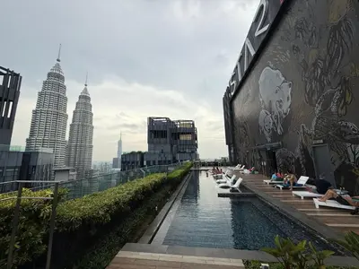 a pool on the side of a building with people sitting at Star Residance KLCC by Nexus 84 in Kuala Lumpur