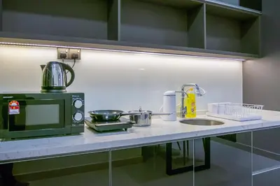 a kitchen counter with a microwave and a sink at NOVO Ampang Stylish Studio & 1BR with Infinity Pool near KLCC & Gleneagles in Kuala Lumpur