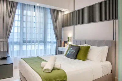a bedroom with a large bed with green and white pillows at NOVO Ampang Stylish Studio & 1BR with Infinity Pool near KLCC & Gleneagles in Kuala Lumpur
