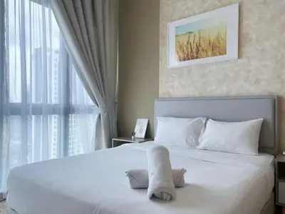 a bedroom with a large white bed and a window at The Colony By Infinitum P in Kuala Lumpur