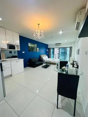 a large kitchen and living room with a glass table at summer suites studios in Kuala Lumpur