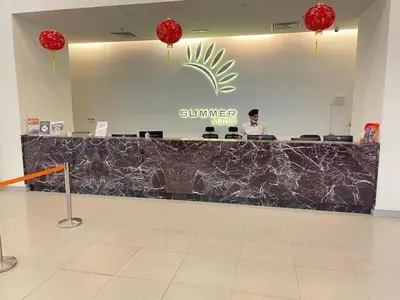 a man is standing at a counter in a store at summer suites studios in Kuala Lumpur