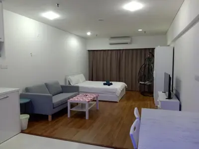 a living room with a couch and a bed and a table at summer suites studios in Kuala Lumpur
