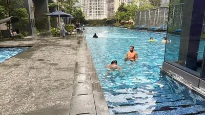 a group of people swimming in a swimming pool at Star Residences KLCC by Nexus 62 in Kuala Lumpur