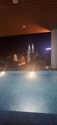 a swimming pool with a view of a city at night at THE COLONY BY INFINITUM by ZENTRIP in Kuala Lumpur
