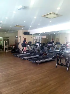 a gym with several people exercising on tread machines at Happy holiday suites at times square KL in Kuala Lumpur
