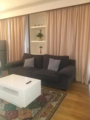 a living room with a black couch and a white coffee table at Happy holiday suites at times square KL in Kuala Lumpur