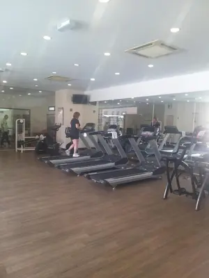 a gym with several people exercising on tread machines at Happy holiday suites at times square KL in Kuala Lumpur