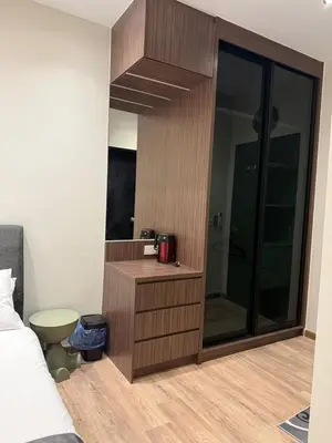 a bedroom with a bed and a wooden cabinet at Alaxis Suite Home By Residensi Brickfields in Kuala Lumpur