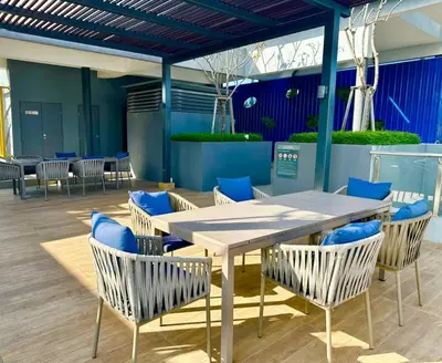 a table and chairs with blue cushions in a room at Neu Suites #2BR Apartment by LammyNora in Kuala Lumpur