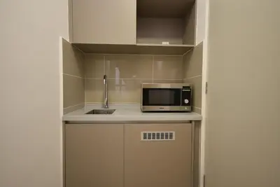 a small kitchen with a microwave and a sink at Trion KL by CityNest in Kuala Lumpur
