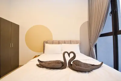 two swans sitting on top of a bed at Trion KL by CityNest in Kuala Lumpur