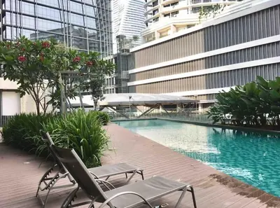 a swimming pool with two chairs and a building at NEW 2BR KL Gateway LRT Midvalley and KLCC, KL Sentral in Kuala Lumpur