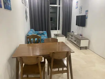 a dining room with a wooden table and chairs at Sky Suites KLCC By Stay Happy in Kuala Lumpur
