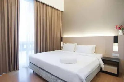 a bedroom with a large white bed and a window at Putra Suite KL in Kuala Lumpur