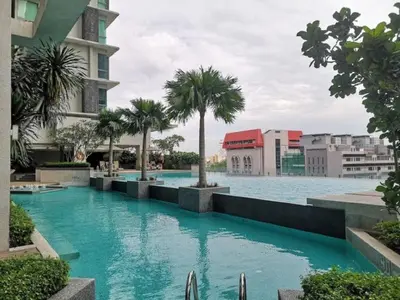 a large swimming pool with palm trees and buildings at Putra Suite KL in Kuala Lumpur