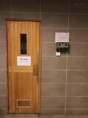 a wooden door in a wall with two signs on it at Putra Suite KL in Kuala Lumpur