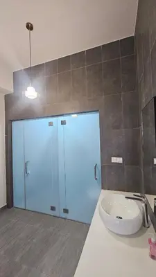 a bathroom with a sink and a glass door at Astoria Ampang City Centre in Kuala Lumpur