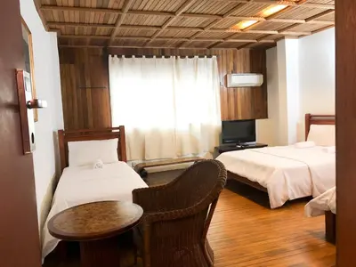 a hotel room with two beds and a table at HOTEL I VILLA INN Bukit Bintang KL in Kuala Lumpur