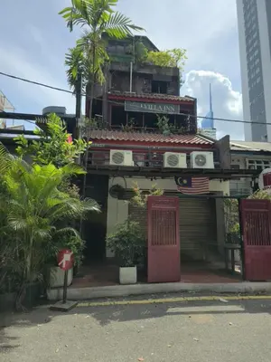 a building with a red door on a street at HOTEL I VILLA INN Bukit Bintang KL in Kuala Lumpur