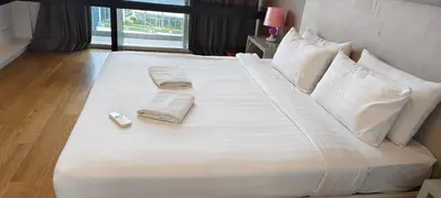 a large white bed with two towels and a remote control on it at platinum suites klcc By Palmas in Kuala Lumpur