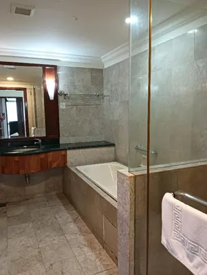 a bathroom with a tub and a sink and a mirror at Crown Suits At Times Square in Kuala Lumpur