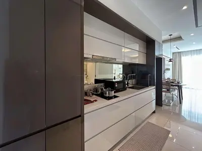 a large kitchen with white cabinets and a table at Elegant Studio - Upscale Neighbourhood of Hartamas in Kuala Lumpur