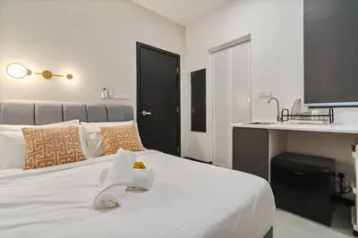 a bedroom with a white bed and a sink at Neu Suites By Propmach in Kuala Lumpur