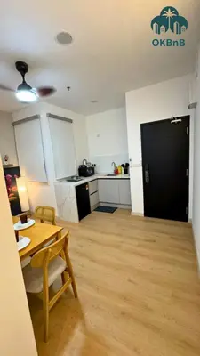 a living room with a table and a kitchen at Neu Suites by OKBnB in Kuala Lumpur